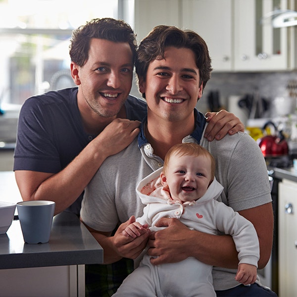 Two gay men holding infant