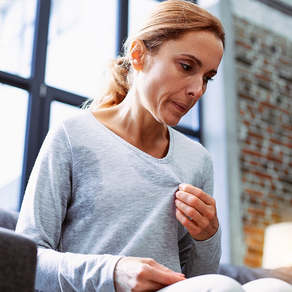 Older woman sweating from menopause