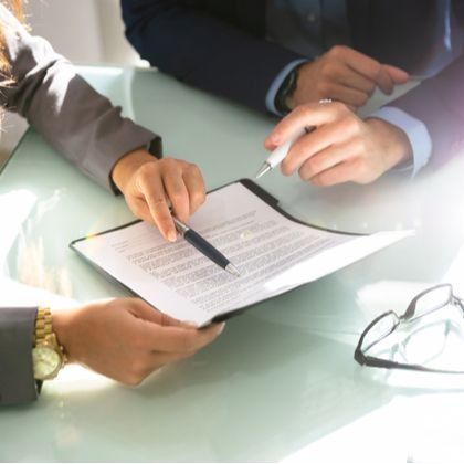 Two people pointing at document