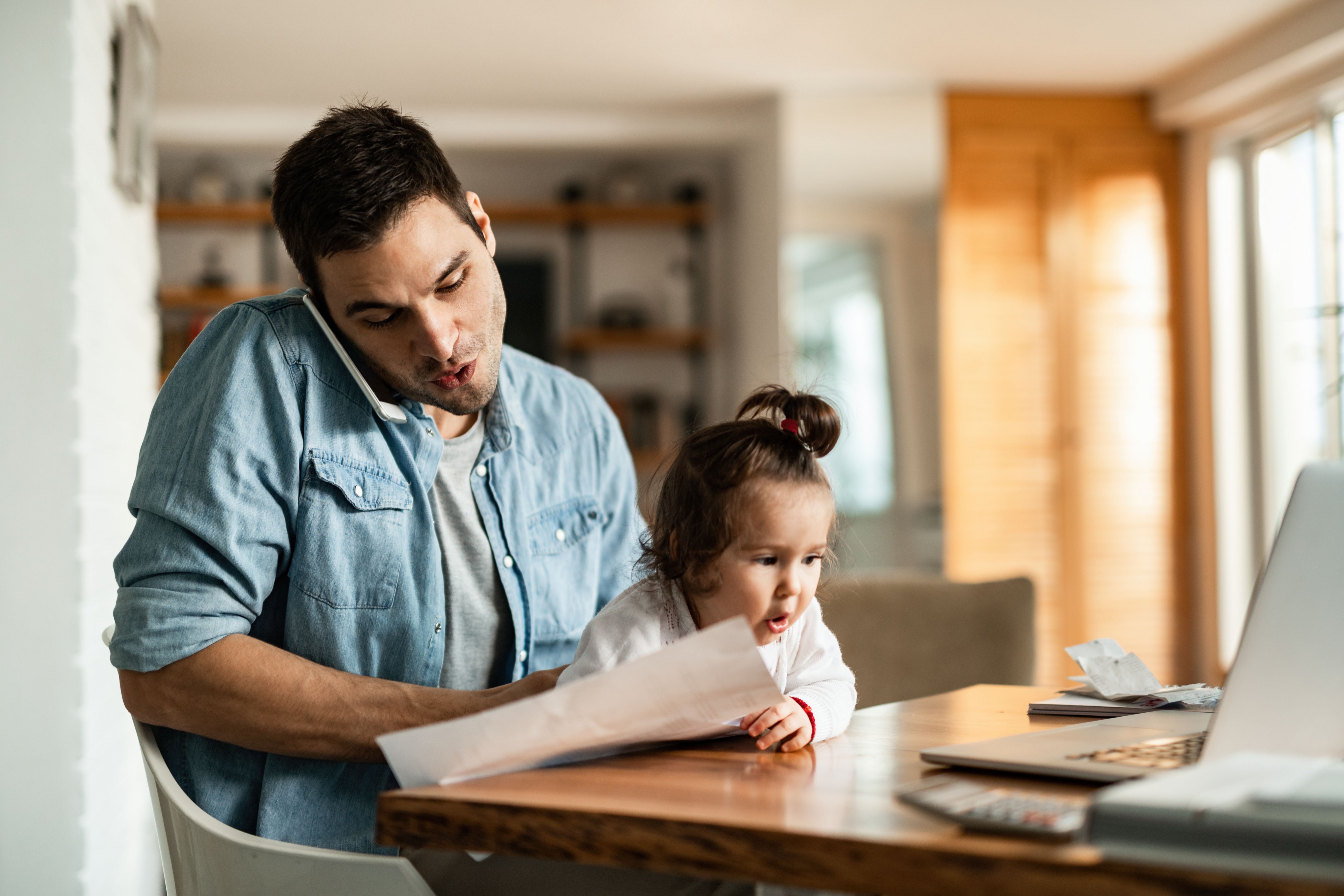 Father holding daughter while calling about delinquent payments