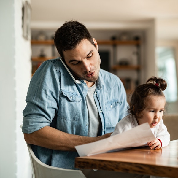 Father holding daughter while calling about delinquent payments