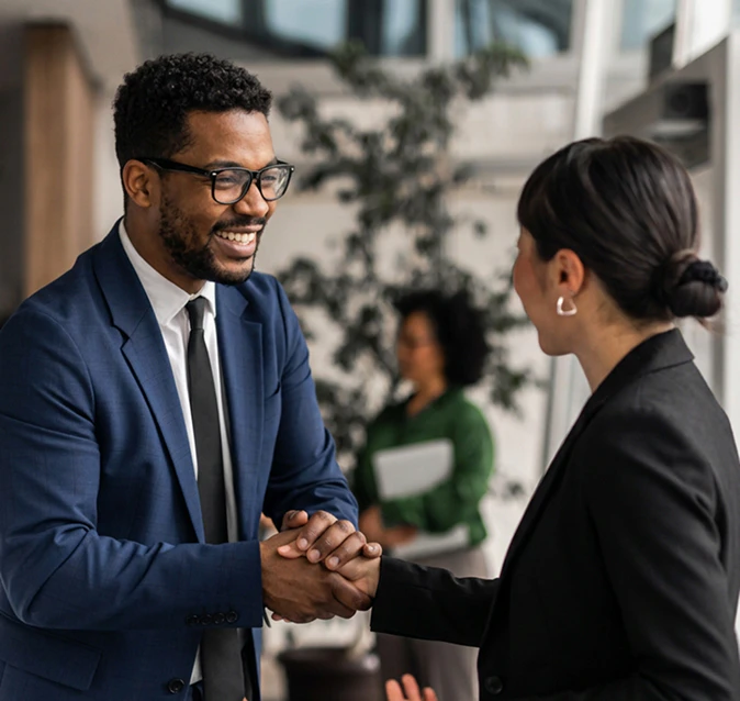 man and woman shaking hands, smiling