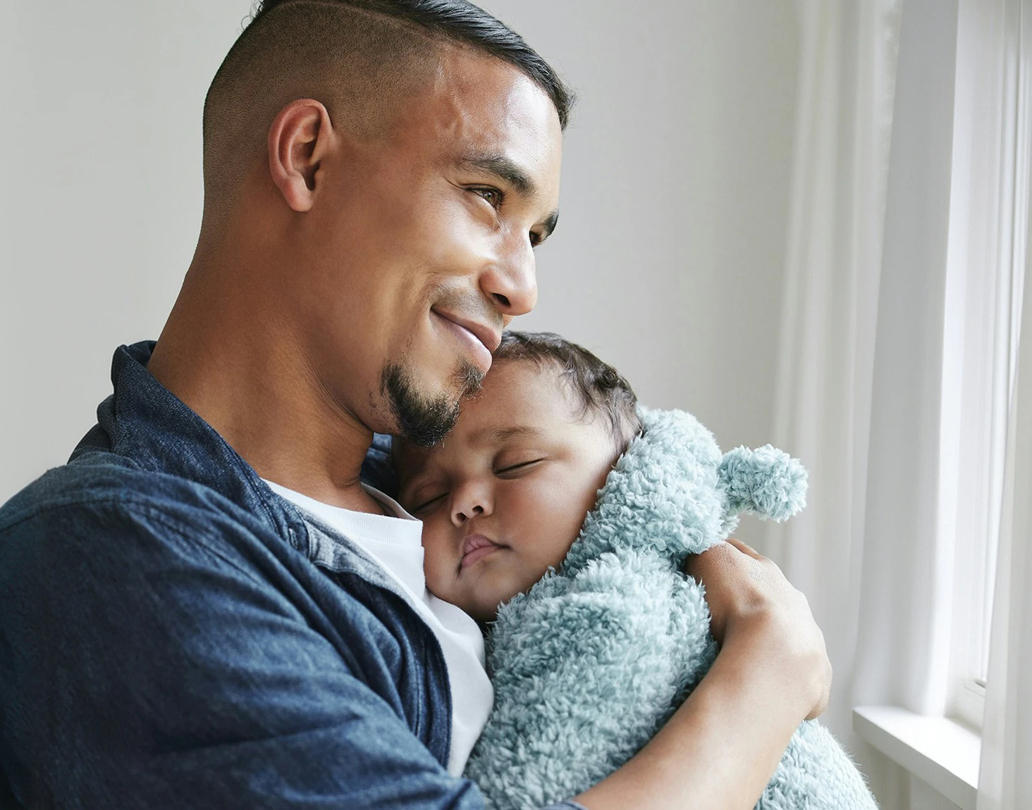 Smiling father holding sleeping baby