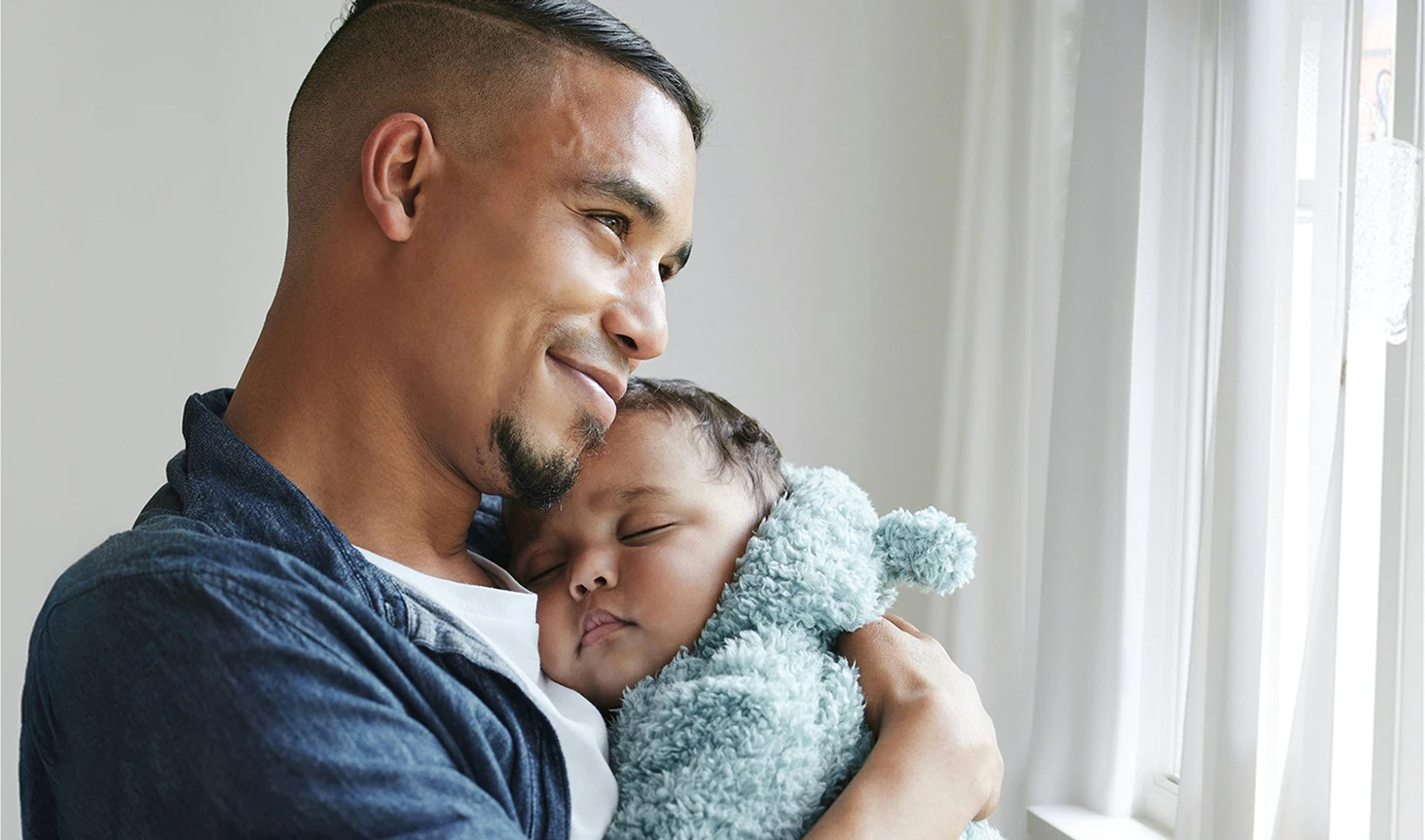 father holding sleeping child