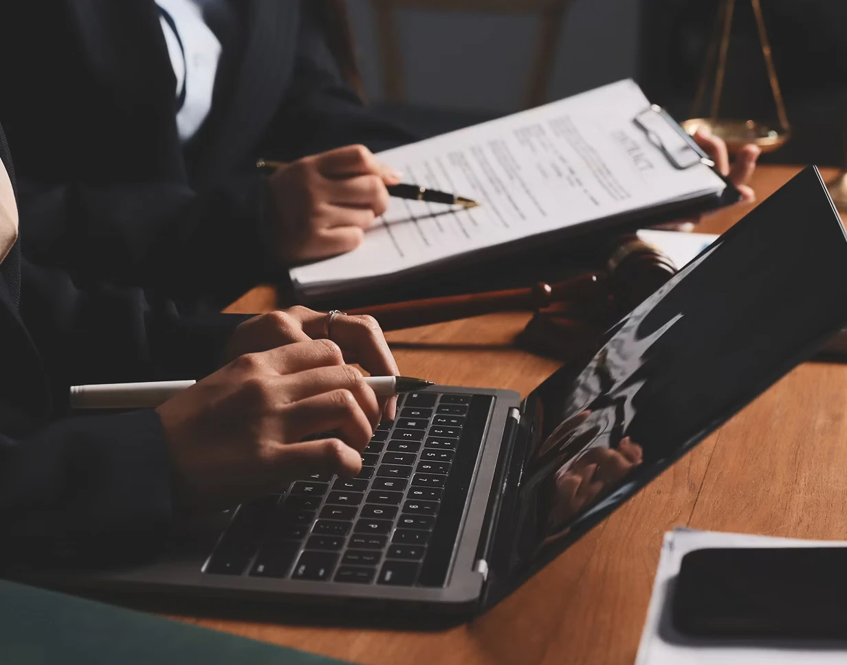 attorneys looking at contracts and laptop