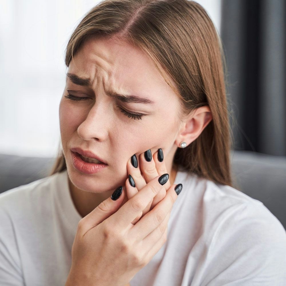 Woman gripping jaw in pain