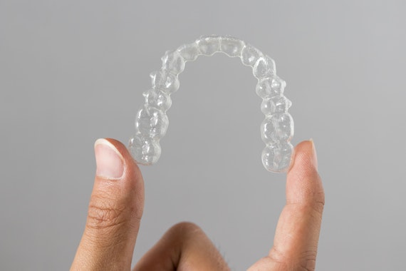 Person holding an Invisalign tray