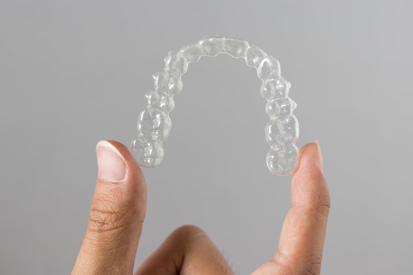 Person holding an Invisalign tray