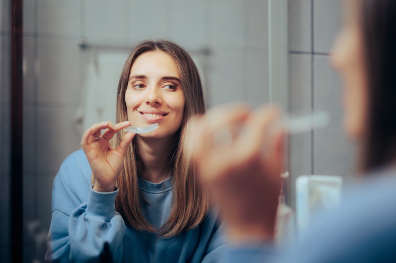 Woman placing teeth whitening tray