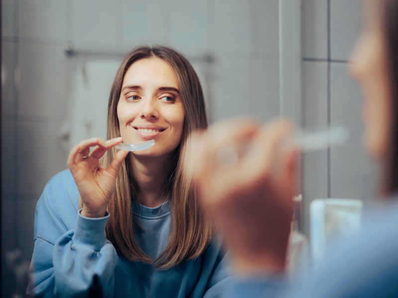 Woman placing teeth whitening tray