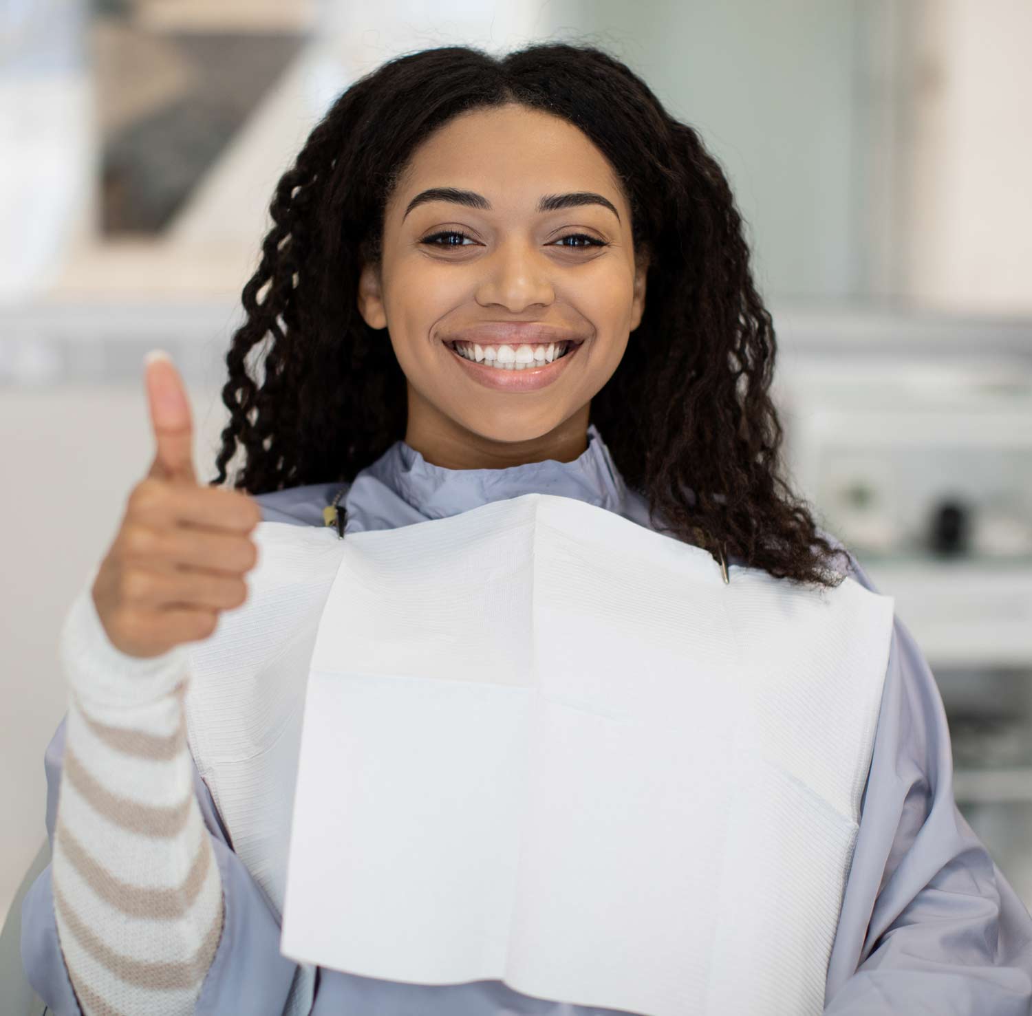 smiling patient giving thumbs up in dental chair