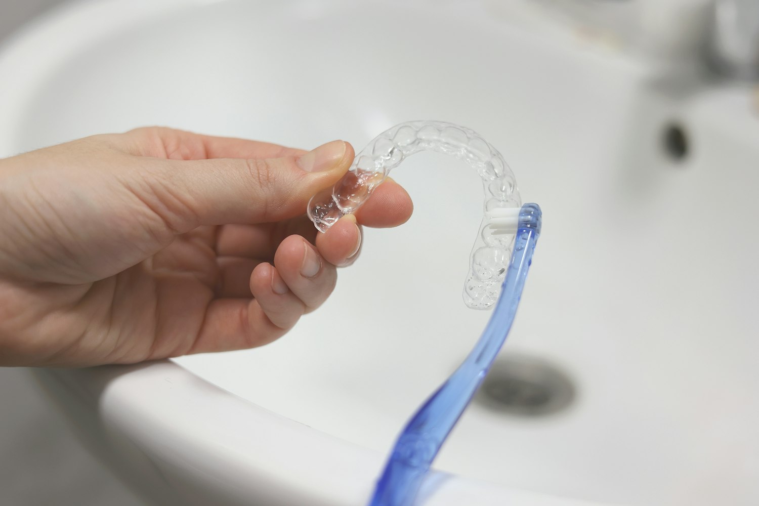 close up of someone brushing their clear aligner