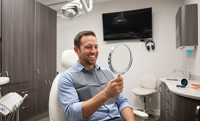Man admiring his smile in a mirror