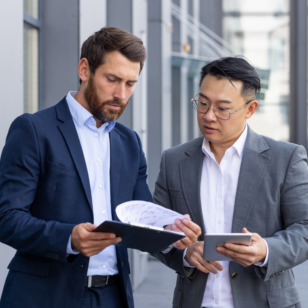 Serious looking men in suits looking at a report