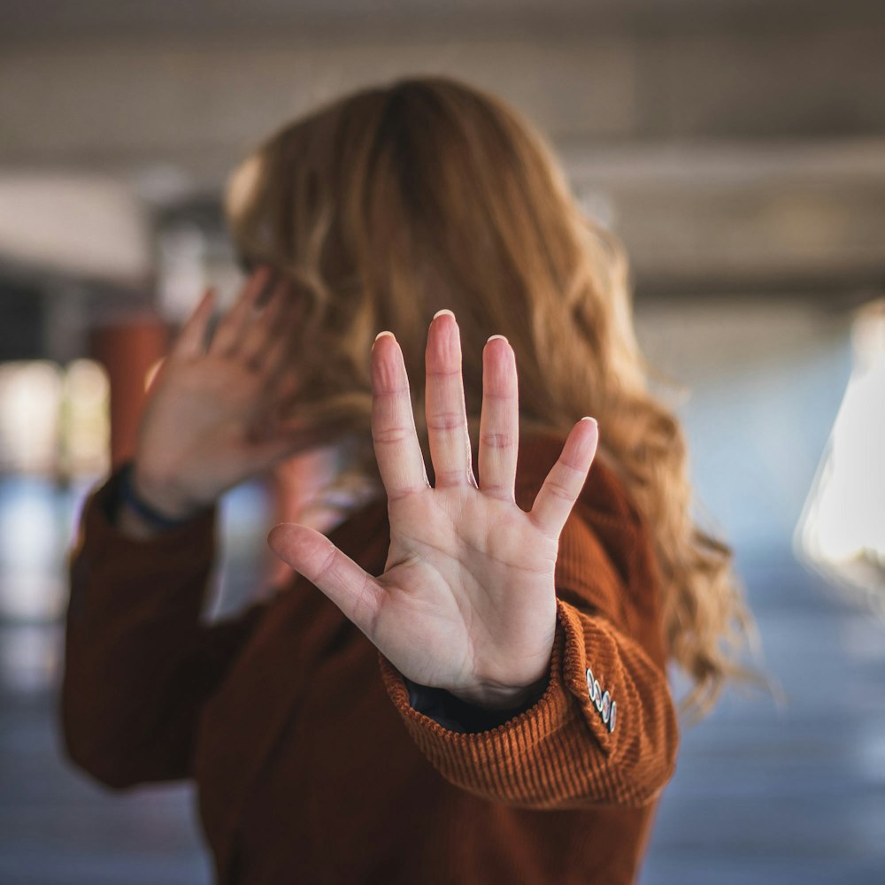 woman putting up hands in defense