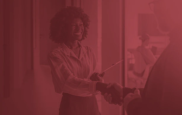 woman smiling, shaking hands with someone