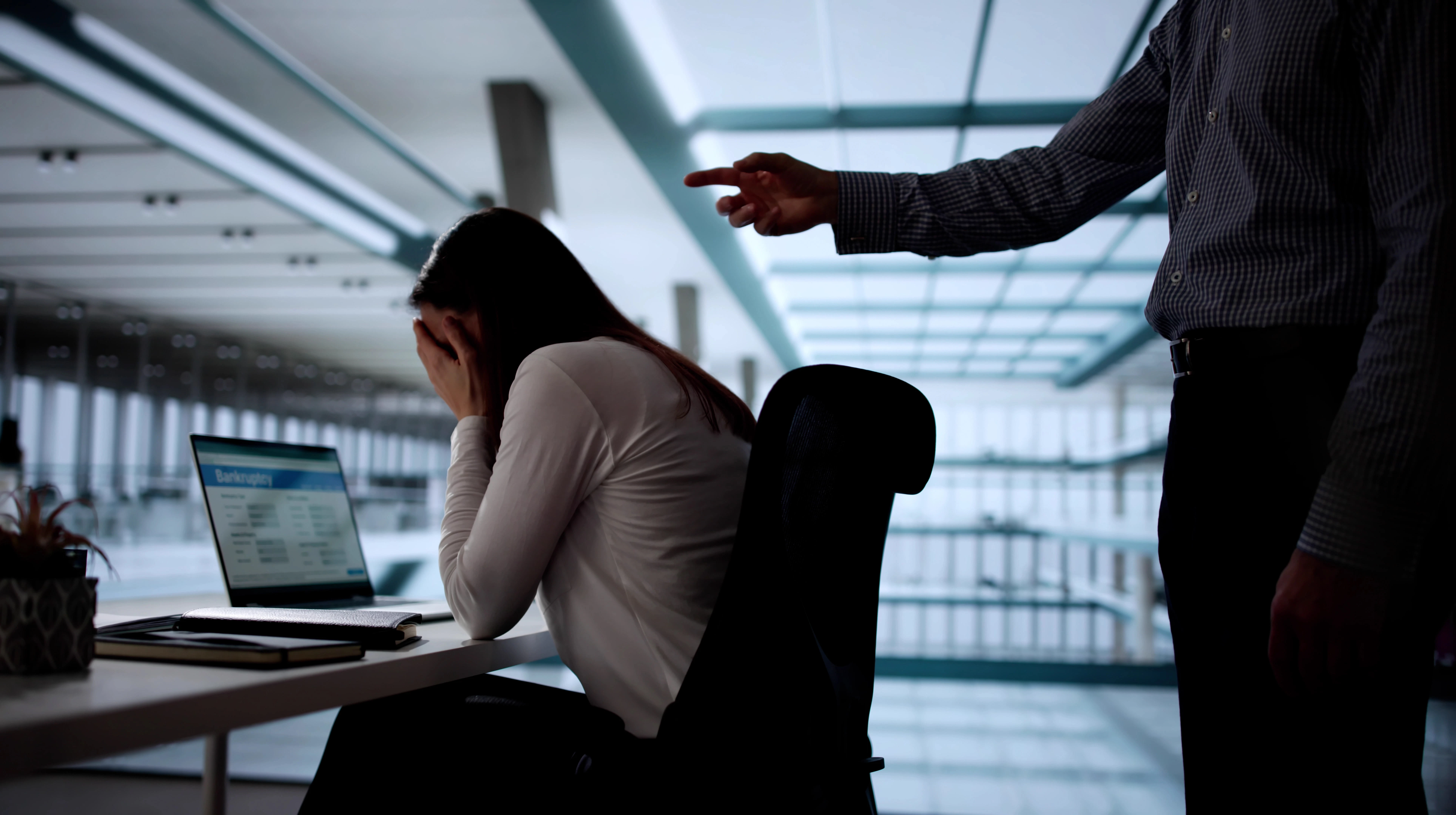 man aggressively pointing finger at woman at work
