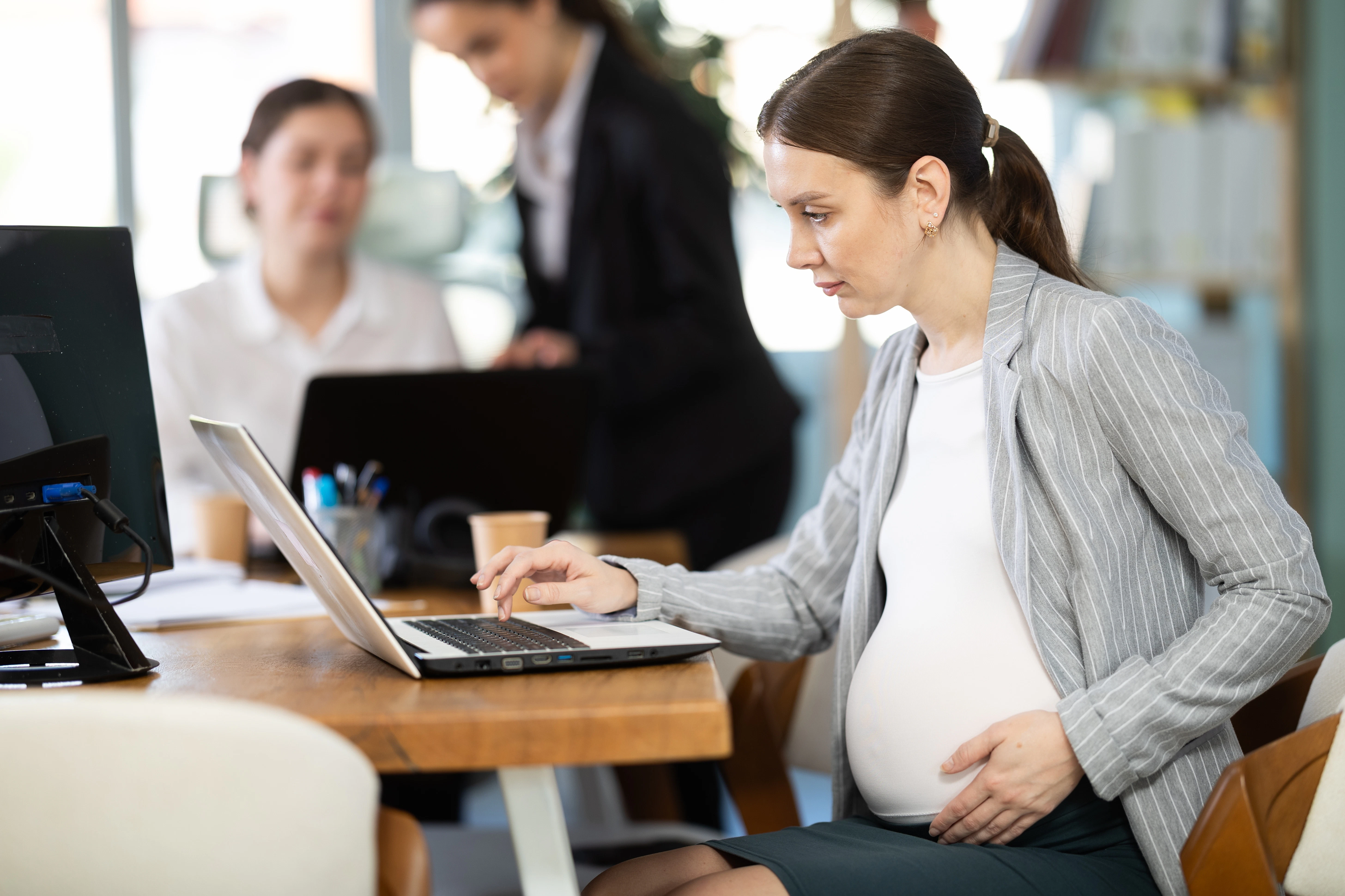 woman working on her laptop while pregnant