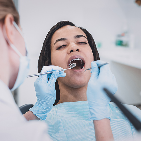 Dental professional examining a patient's smile