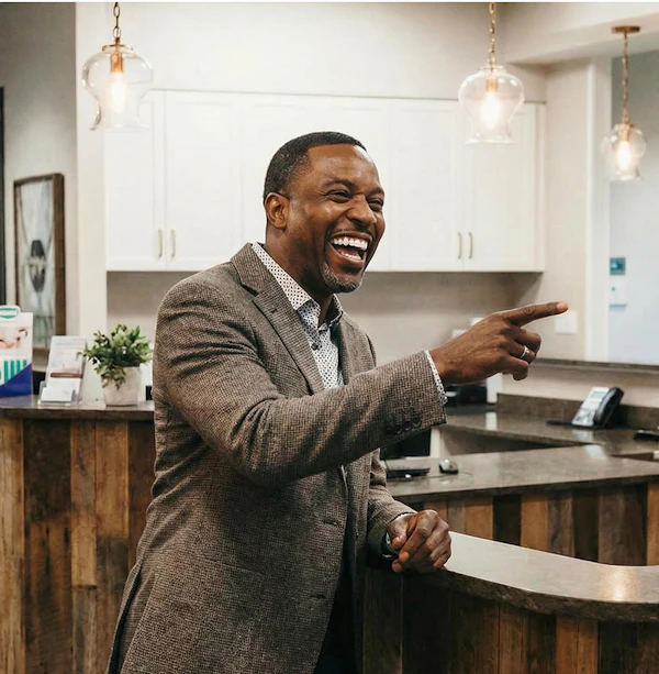 Smiling patient laughing at a dental office front desk
