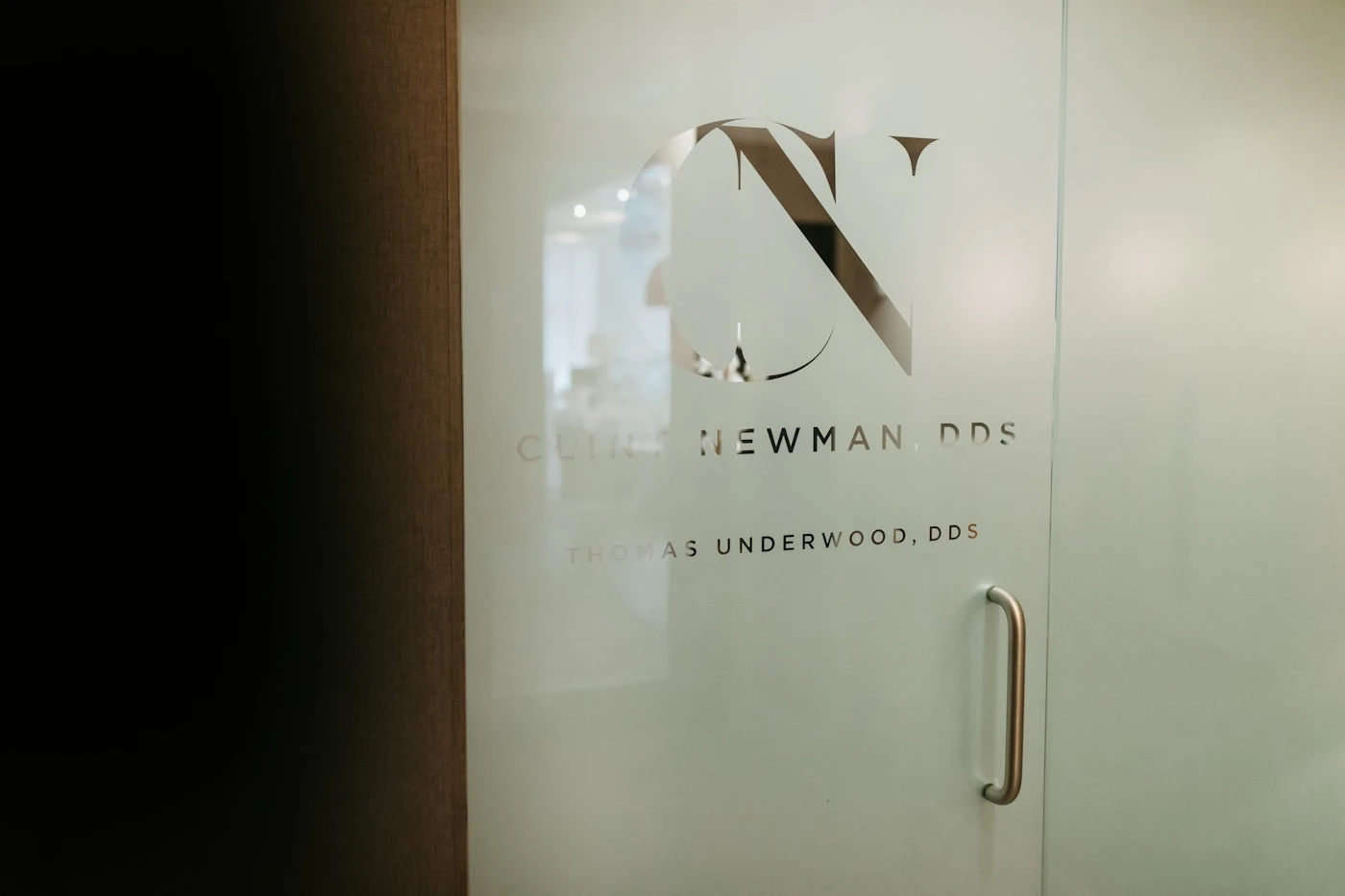 Frosted glass entry door with the Clint Newman, DDS logo