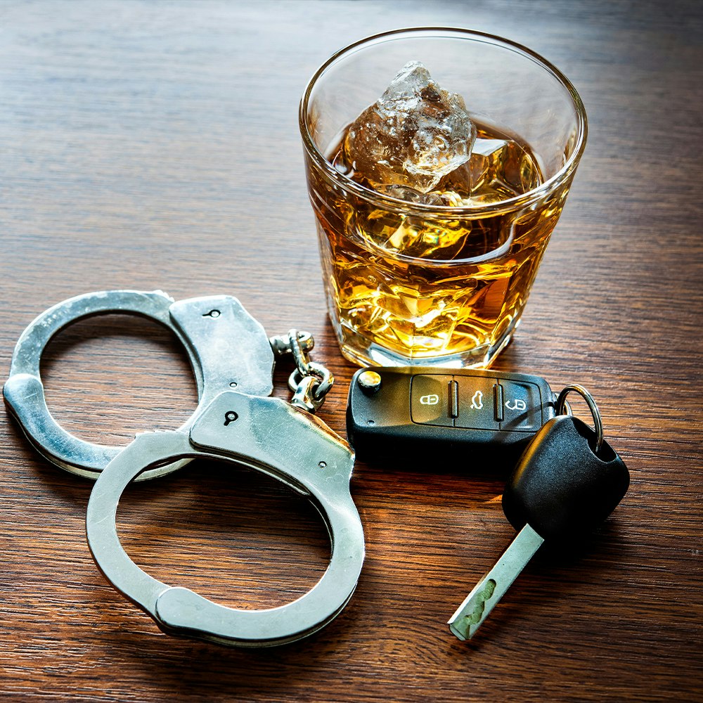handcuffs, alcohol and car keys on a table