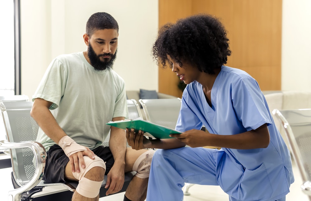 Injured motorcycle rider speaking with a medical professional at the hospital