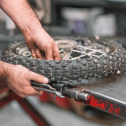 Mechanic working on a damaged motorcycle tire