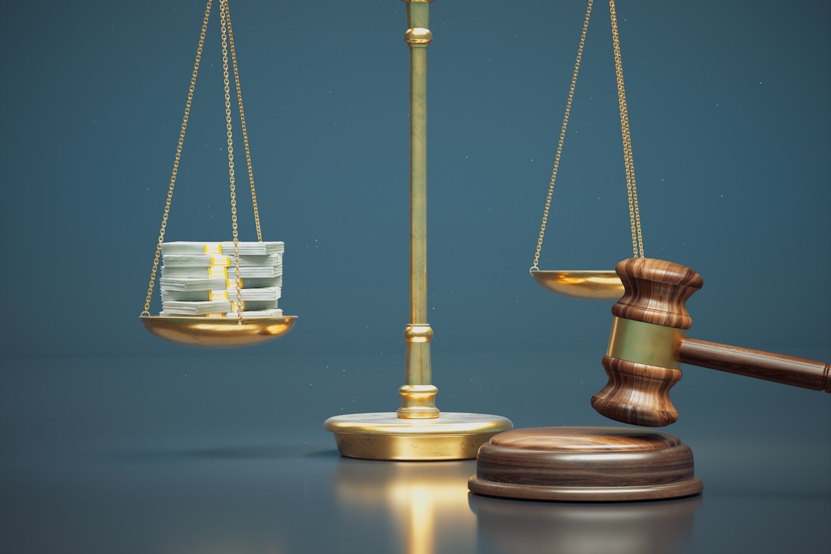 Gold balance scale with a stack of cash on one side and a wooden gavel beside the empty other side, set against a blue background.