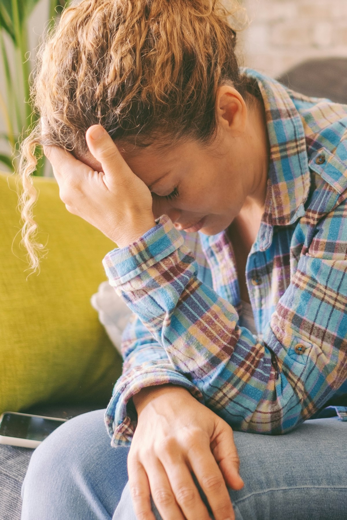 woman holding head in hands
