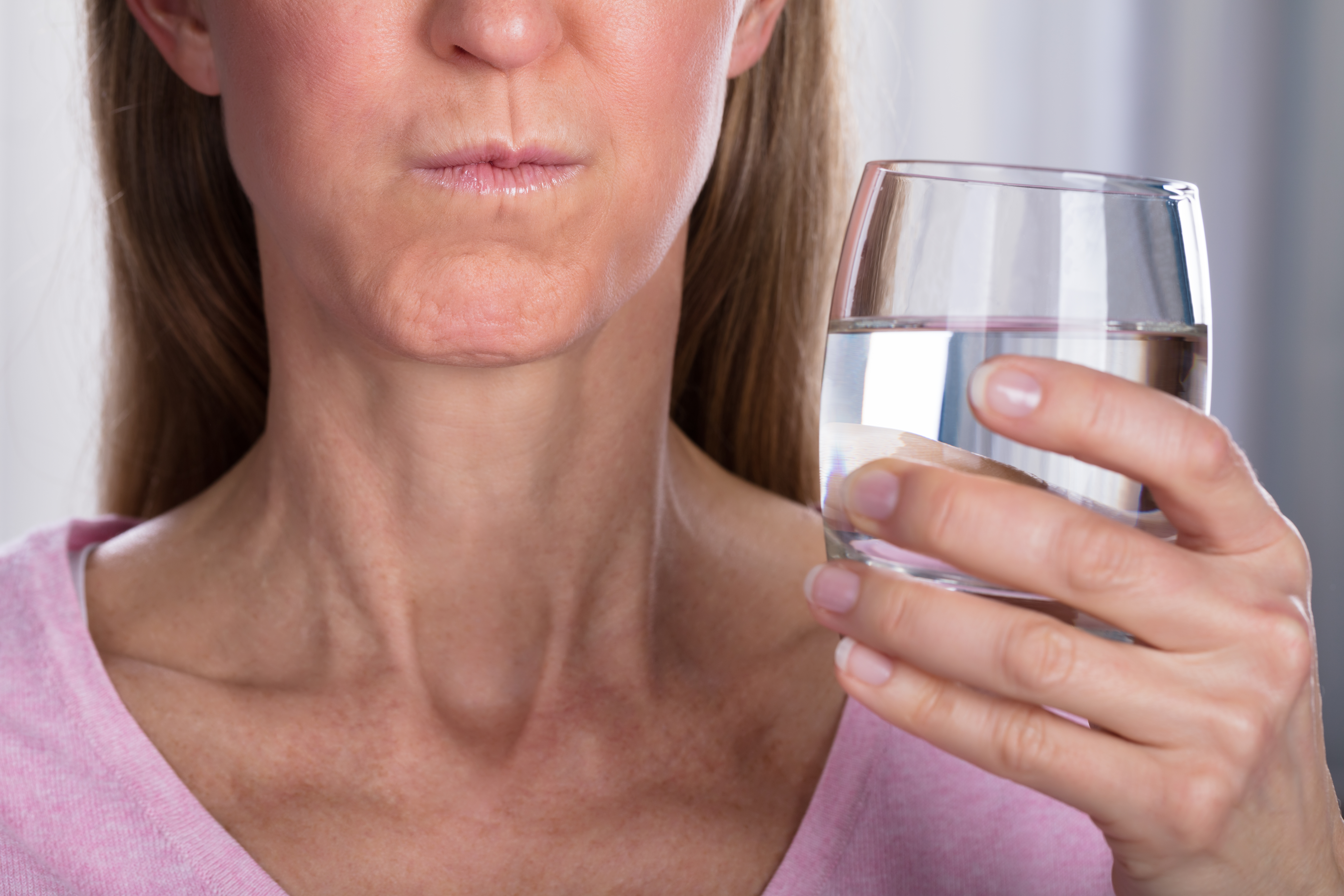 Close-up of woman rinsing her mouth out with water
