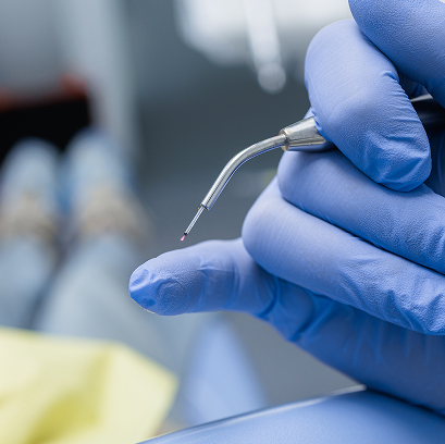 gloved hand holing dental tool
