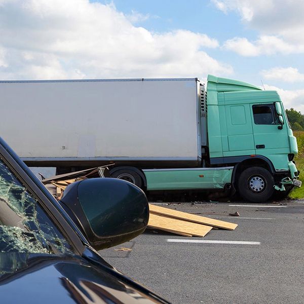 Broken car windshield with truck in the background