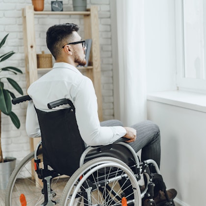 man in wheelchair gazing out the window
