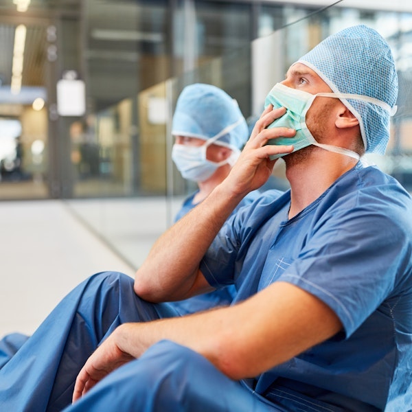 Doctors sitting on the ground looking sad