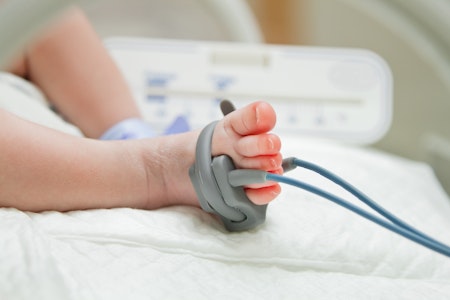Close-up of a baby's foot with a monitor