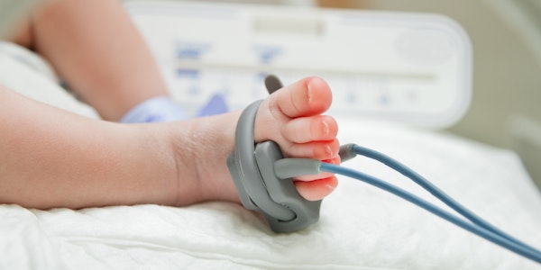 Close-up of a baby's foot with a monitor