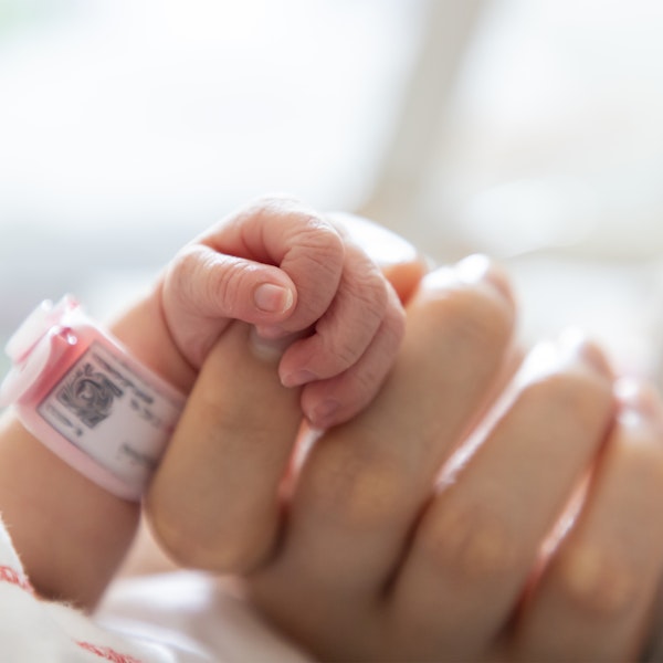 Close-up of mother's hand holding newborn baby's friend