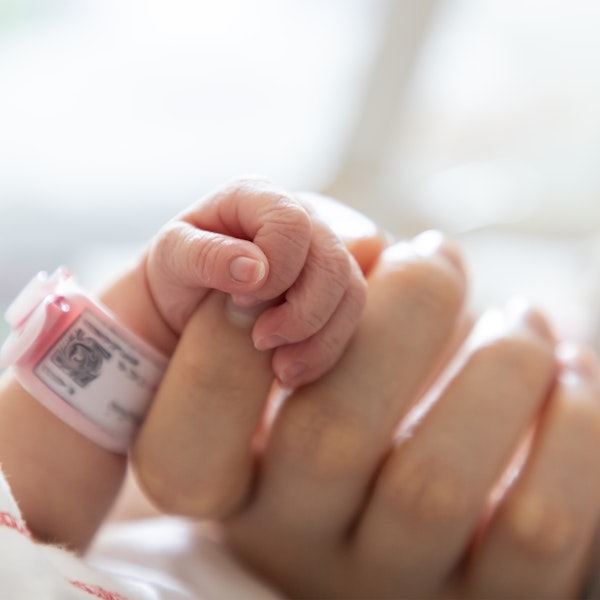 Close-up of mother's hand holding newborn baby's friend