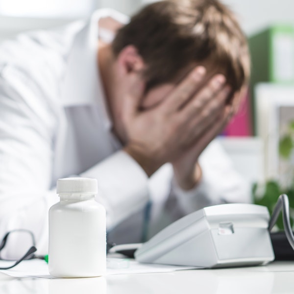 Upset doctor near a pill bottle