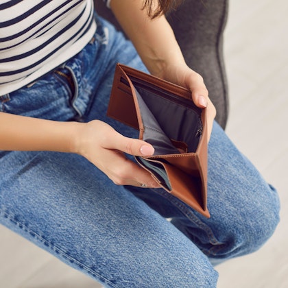 Person holding empty wallet after a car accident