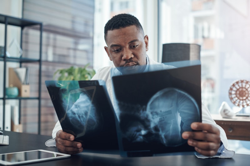 Male doctor examining skull X-rays in a modern medical office