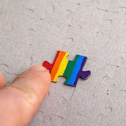 Finger pointing to rainbow puzzle piece