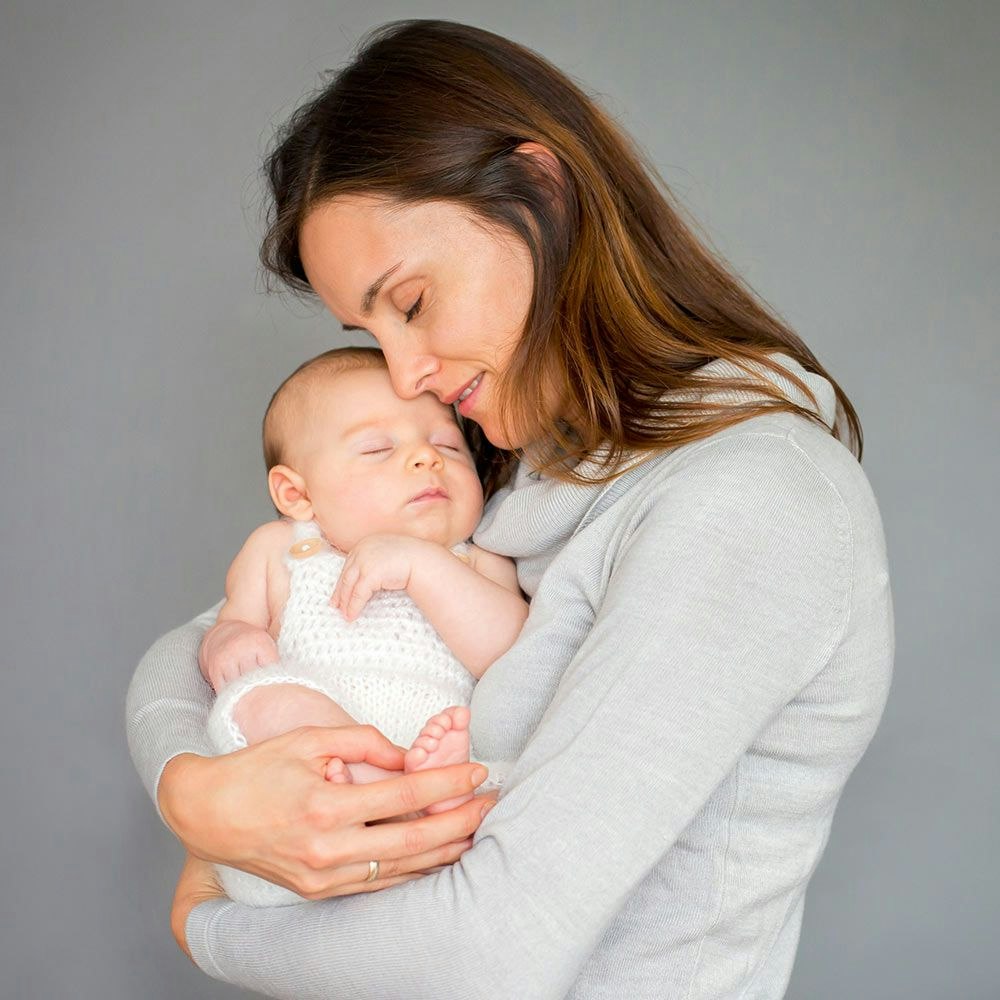 Mother hugging newborn baby