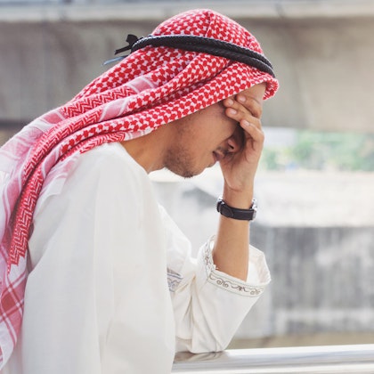 Middle eastern man with head in hands