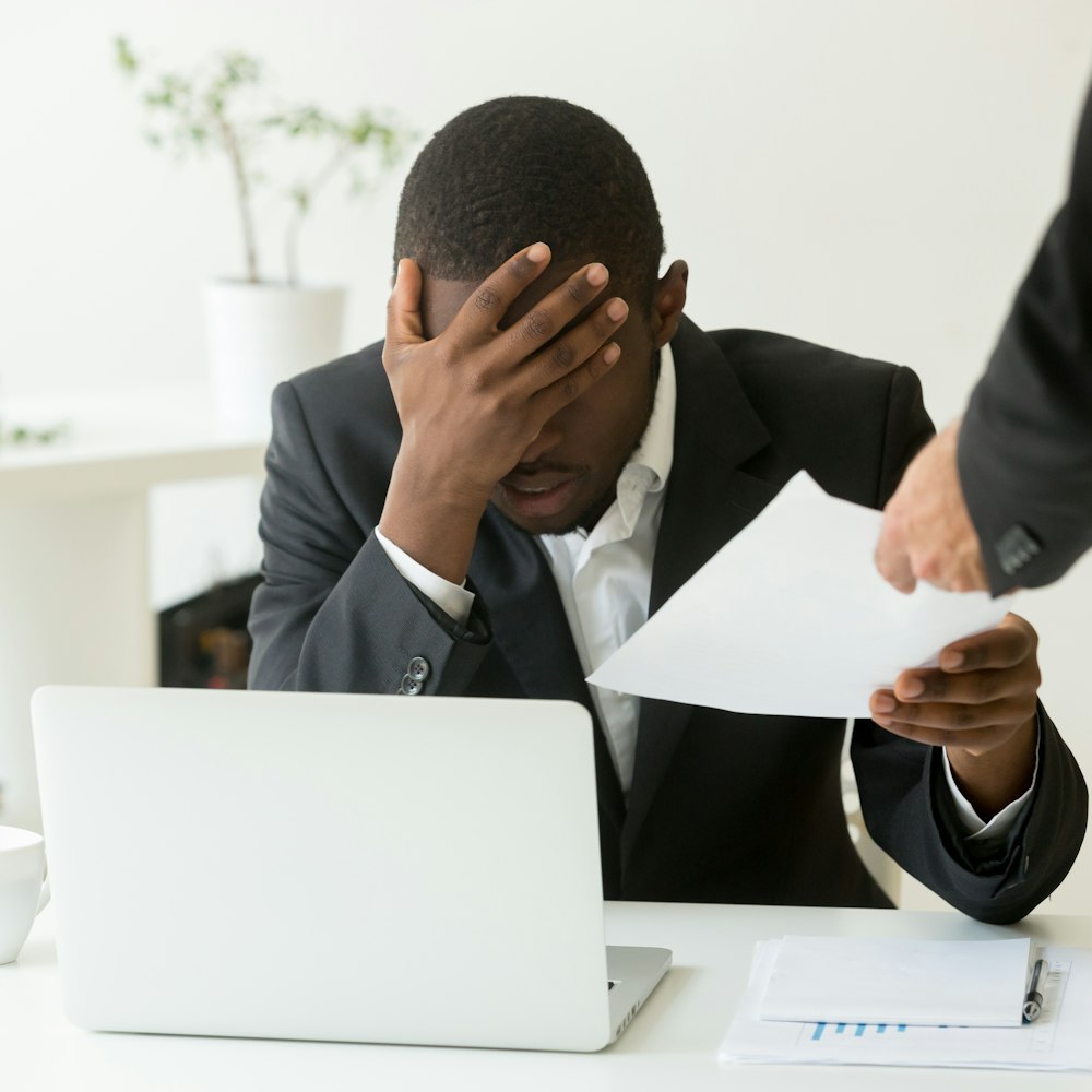 Man upset at work while grabbing a piece of paper