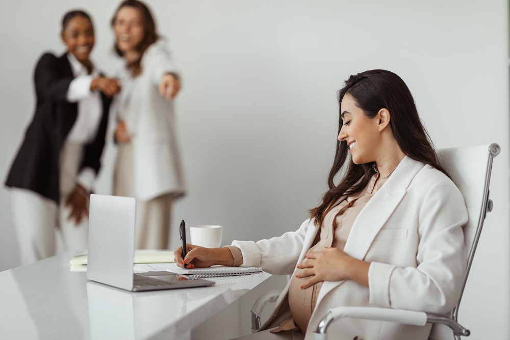 Pregnant woman smiling at work