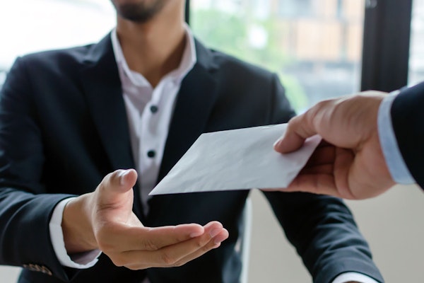 man being handed an envelope full of cash