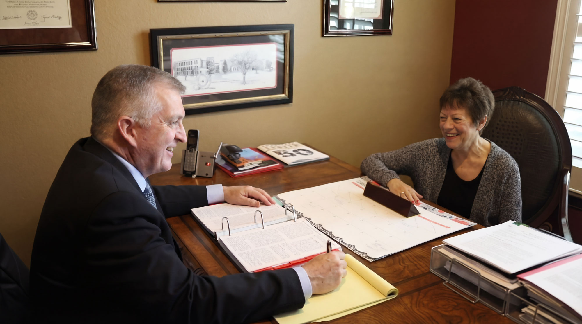 Dan A. Atkerson at desk with client