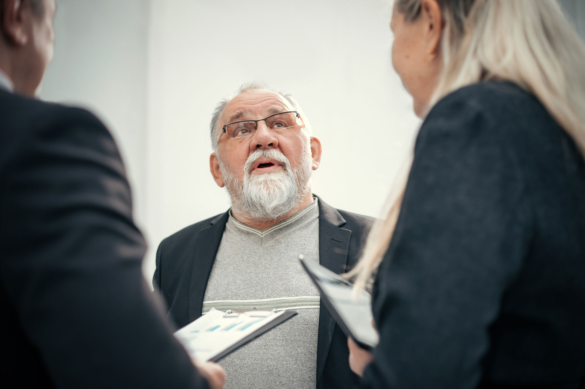 Older man talking to two other people